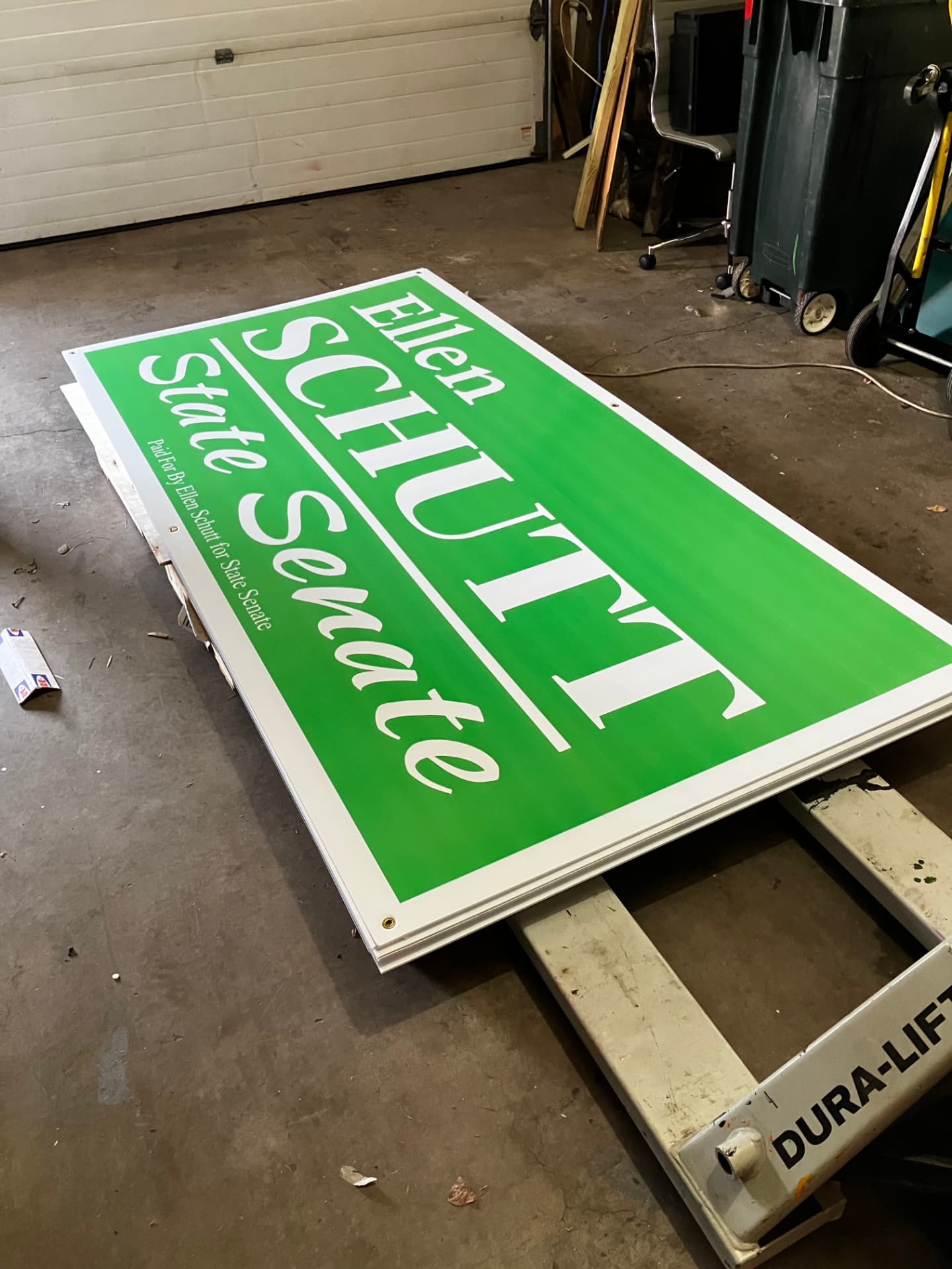 Finished green Ellen Schutt for State Senate 4 by 8 foot campaign signs stacked in the Madison print shop